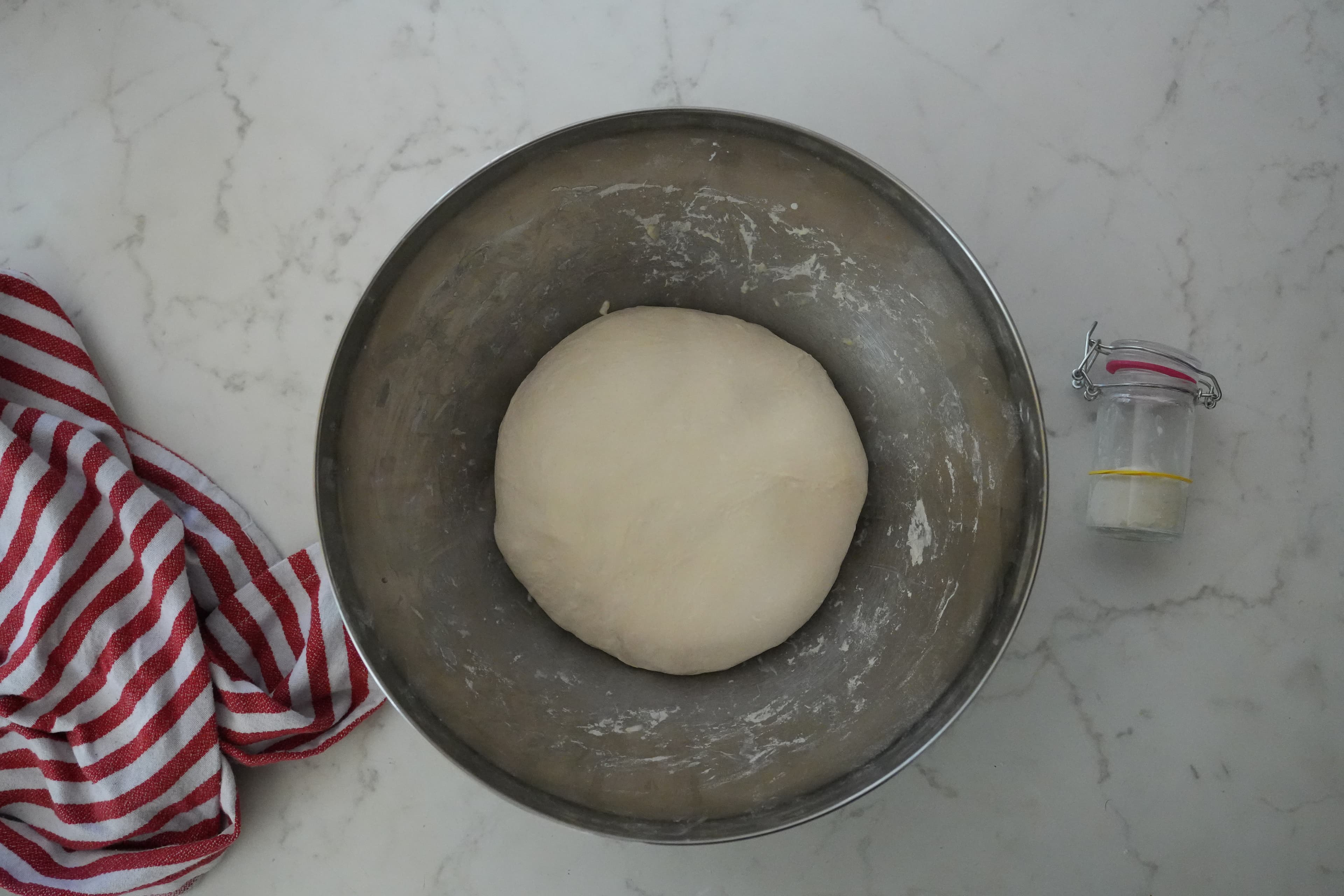 Dough in a small container with a marked start line for bulk rise.