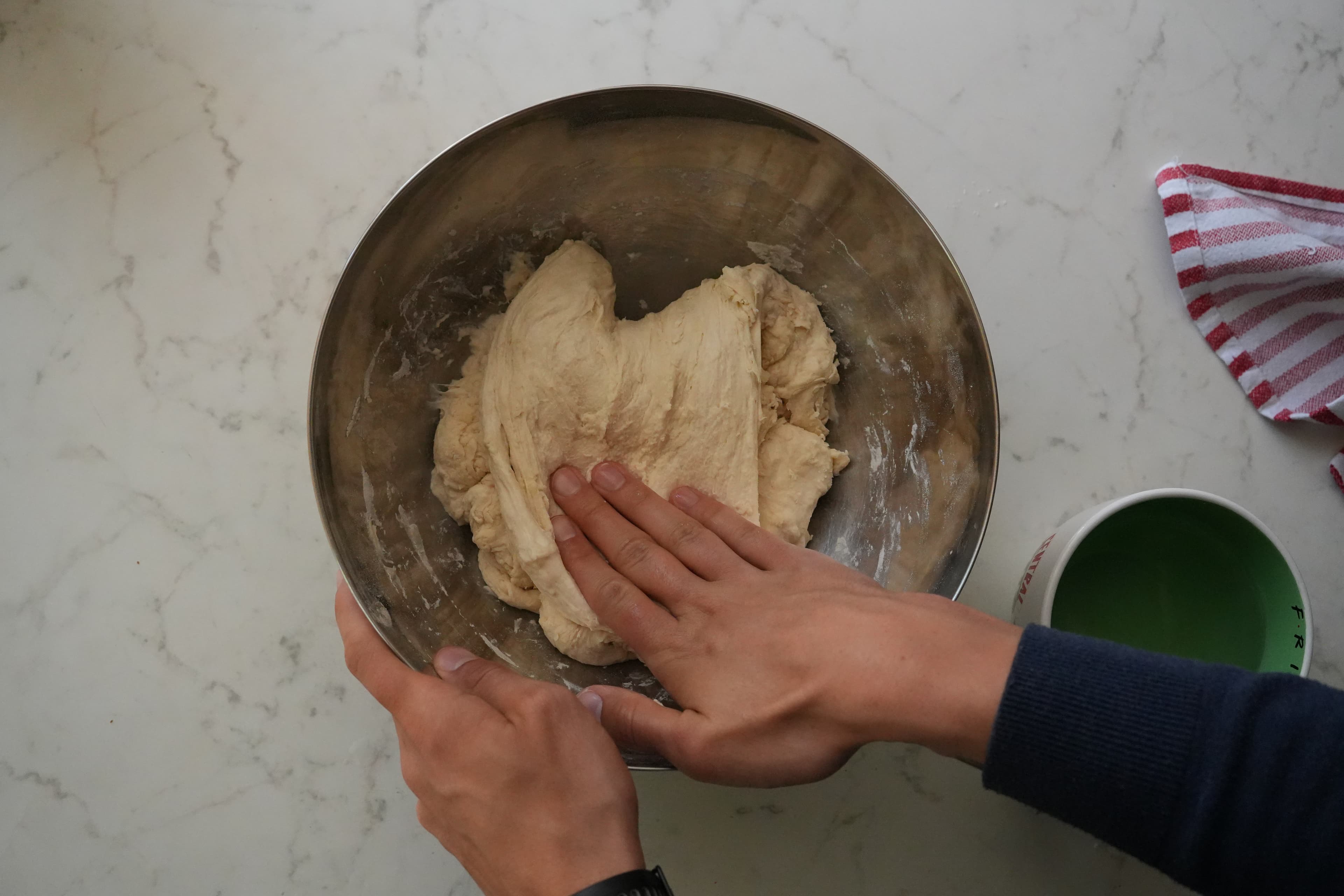 Second stretch and fold angle with hands lifting the dough.